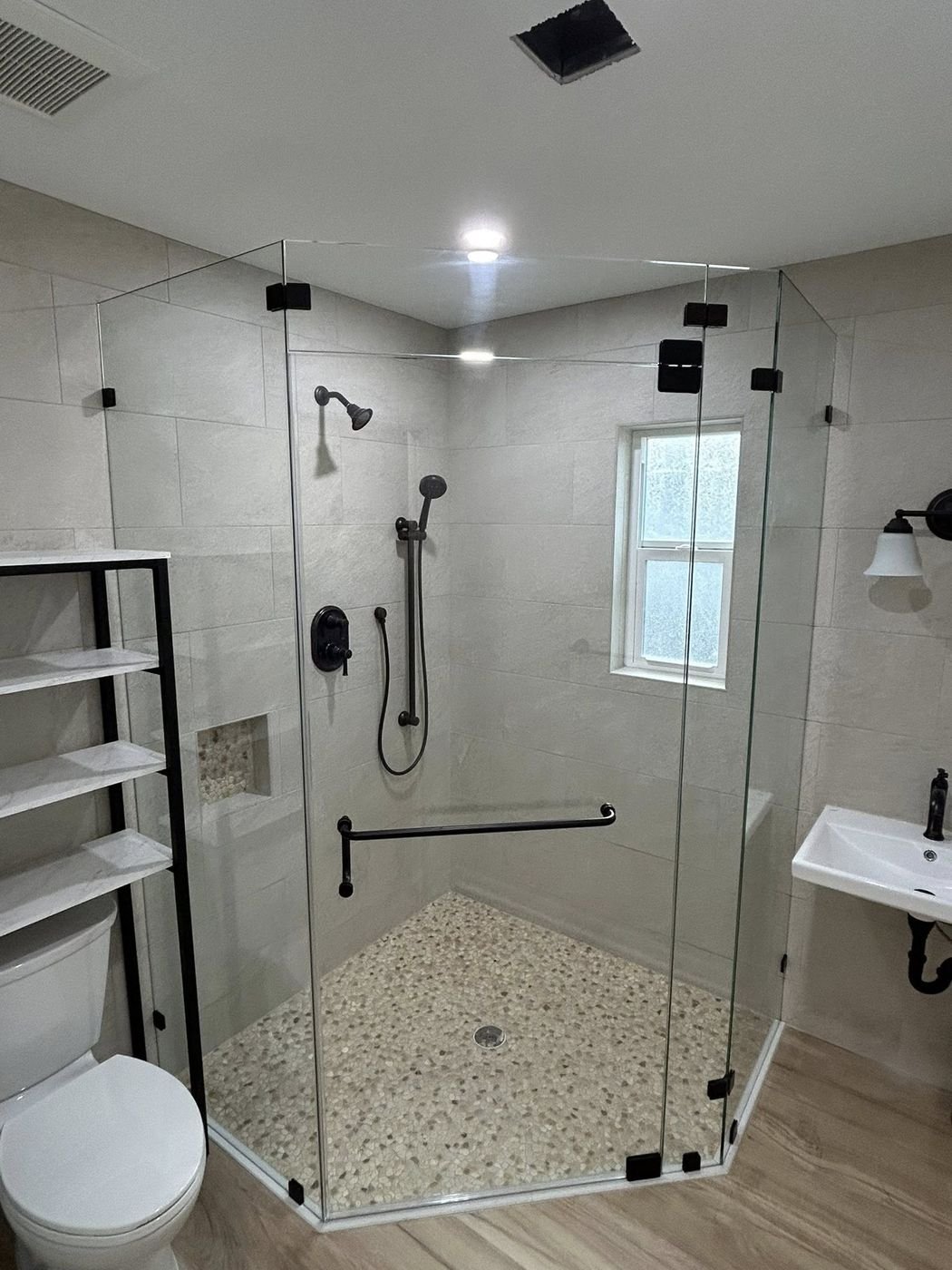 Neo-angle frameless shower enclosure with black hardware
